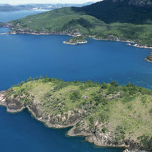 Aerial view over the two bays of Chance Bay and surrounding forested hills of Whitsunday Island